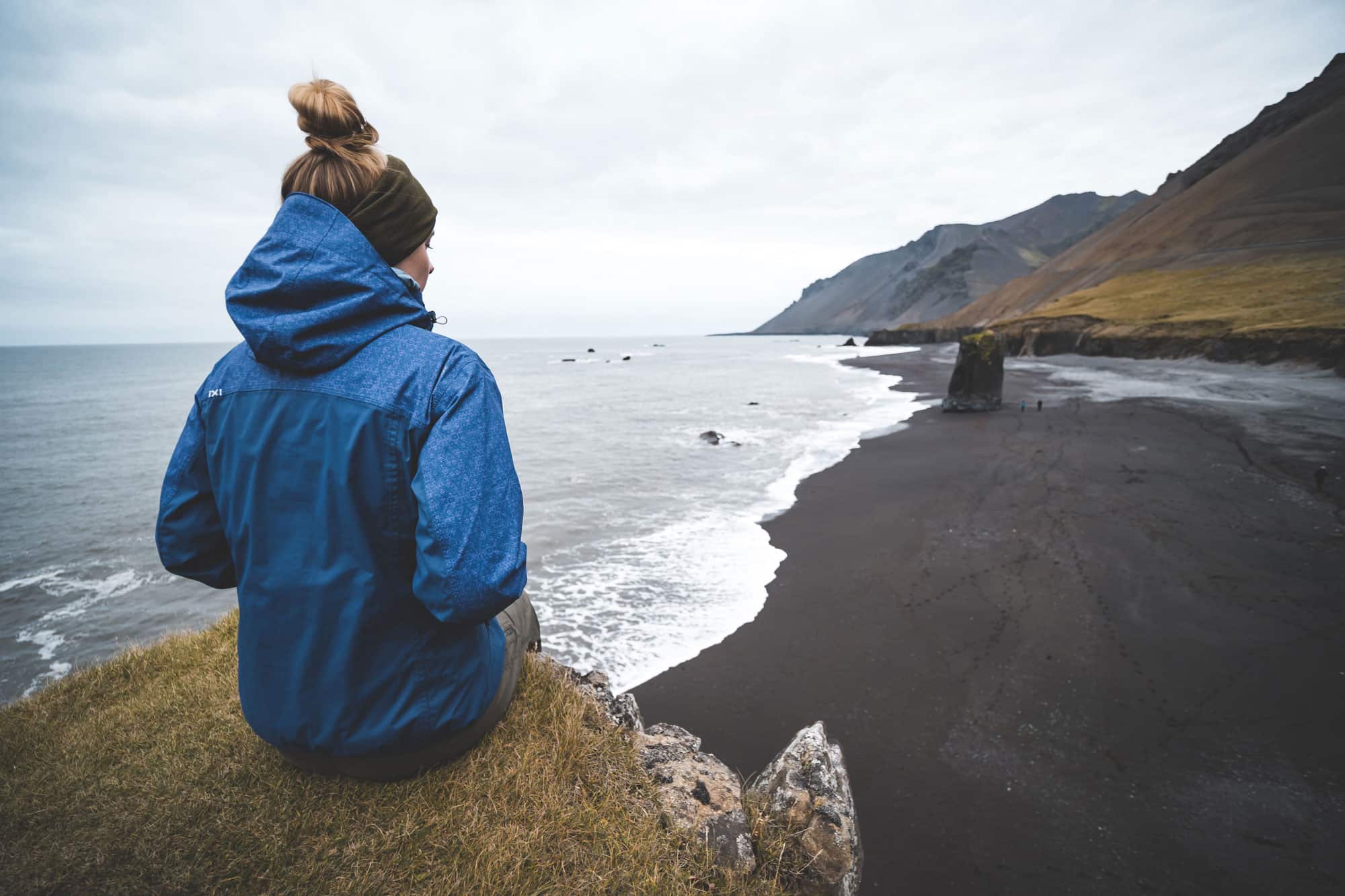Mujer viajando sola, contempla paisaje Islandia